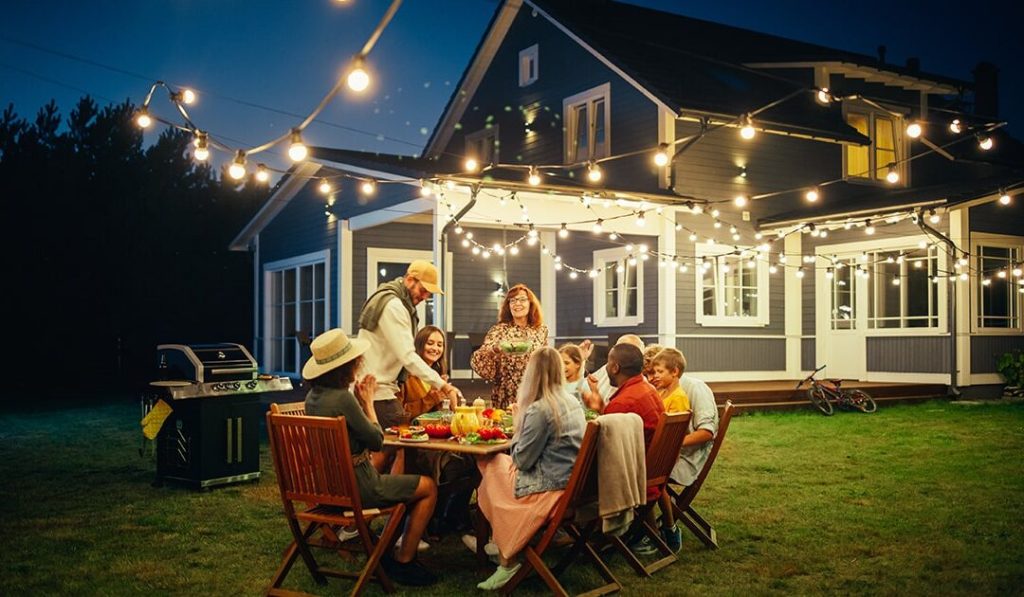 People gathered for a backyard party at dark - 5 ways to make the most of your summer evenings
