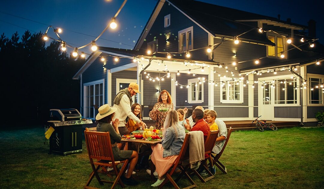 People gathered for a backyard party at dark - 5 ways to make the most of your summer evenings