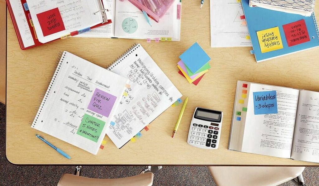Desk with papers, books, and calculator - Post-it super sticky notes
