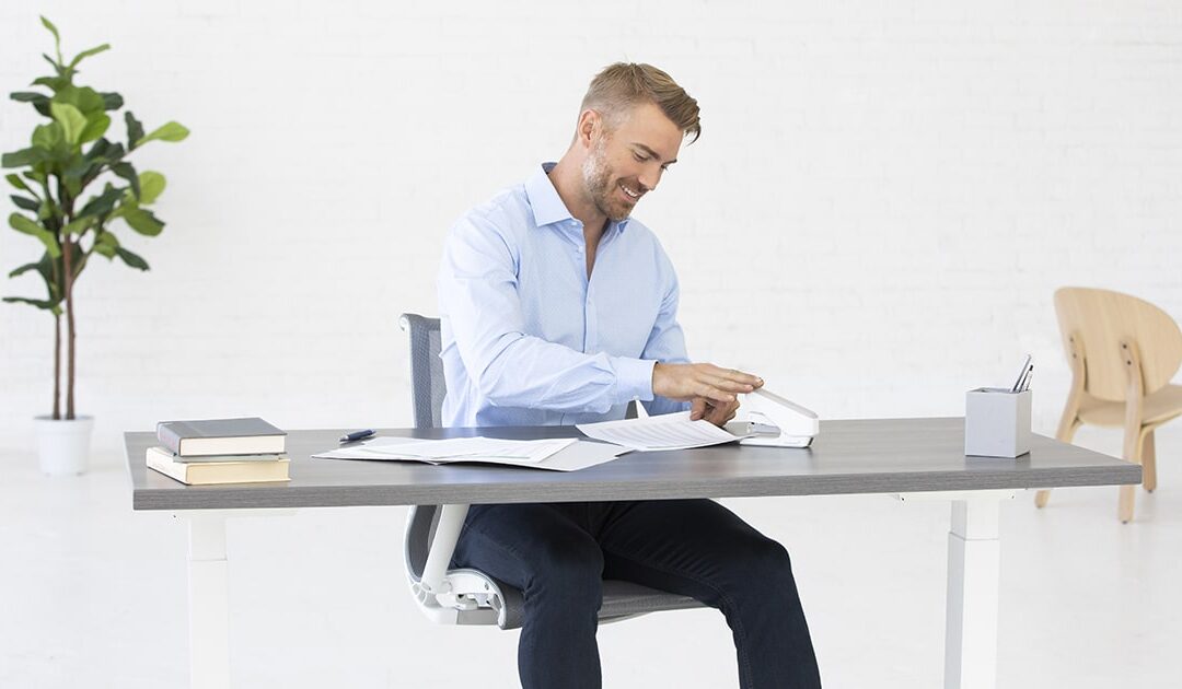 Man using a Fellowes Stapler at a desk