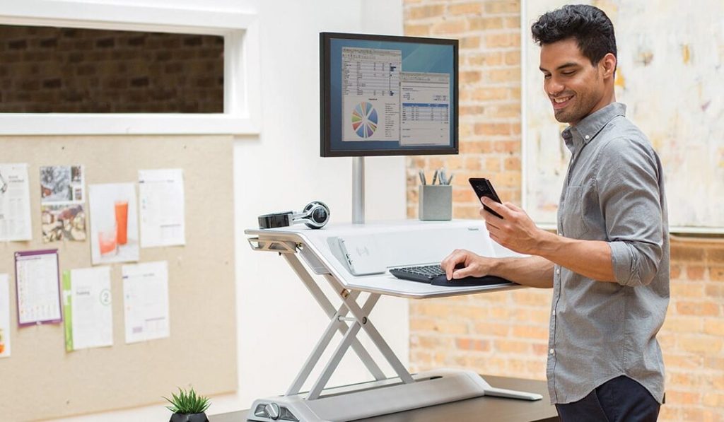 Man at a standing work desk - Fellowes Anti-Fatigue Wellness mat