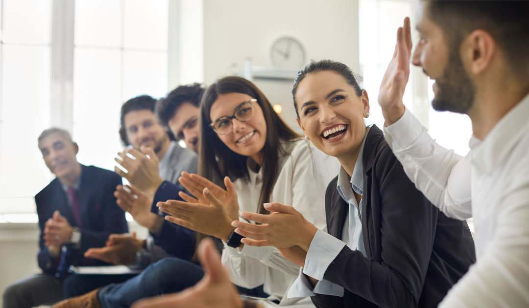 Group of business professionals clapping - why employee recognition is key to retaining top talent